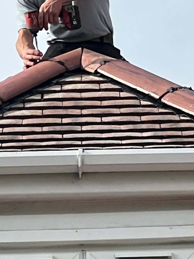 This is a photo of one of the operatives of Halesowen Roofing Repairs installing new ridge tiles